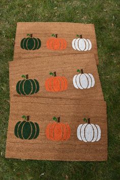 two rugs with pumpkins on them sitting in the grass