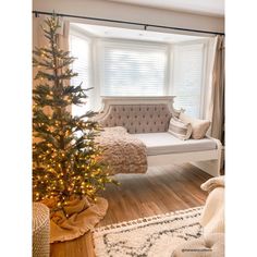 a living room with a christmas tree in the corner and a couch next to it