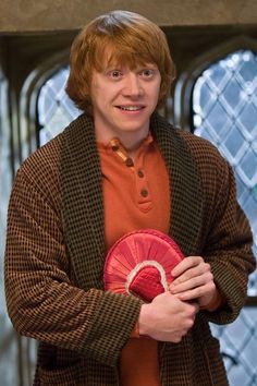 a man holding a red frisbee in front of a stained - glass window