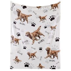 a white blanket with dogs and paw prints on it, which says ma'av