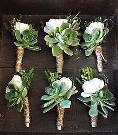 wedding bouquets with white roses and succulents arranged on a wooden table