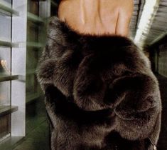 a close up of a person's hand wearing a fur coat