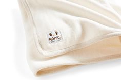 a white blanket with the hanks logo on it's front and back side