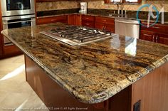 a kitchen with granite counter tops and stainless steel appliances in the center island, surrounded by wooden cabinets