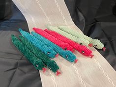 four crocheted alligators sitting on top of a white cloth covered tablecloth