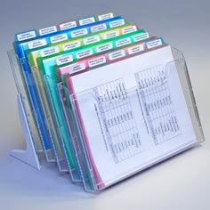 a stack of folders sitting next to each other on top of a white table