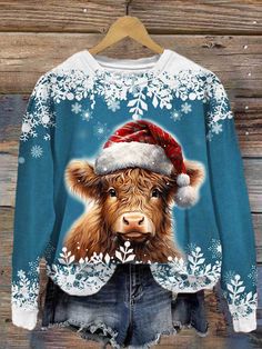 a sweater with an image of a cow wearing a santa hat and snowflakes on it