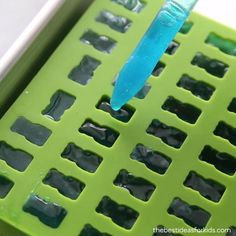 a blue toothbrush sitting on top of a green plastic tray with holes in it