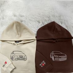 two hoodies with cars on them are sitting on a white furnishing floor