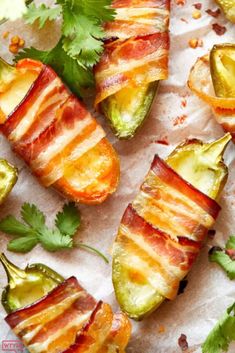 bacon wrapped jalapenos with avocado and cilantro on parchment paper