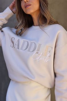 Welcome to the club! Saddle up in style with our Saddle Club Embroidered Sweatshirt. Featuring tone-on-tone lettering embroidered on the front of this crewneck pullover for a subtle but stylish effect. Relaxed fit, mid-weight sweatshirt constructed of a cotton/poly fleece blend. Stylish Equestrian, Saddle Club, Horse Sweater, Horse Sweatshirts, Horse Fashion, Embroidered Sweatshirt, Sleeve Cuff, Branding Photoshoot, Horse Girl