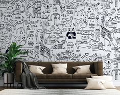 a couch sitting in front of a wall covered in black and white doodles