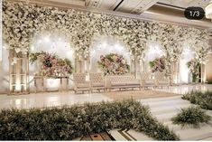 an elegant wedding setup with flowers on the wall