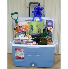 a blue cooler filled with lots of items and a blue bow on top of it