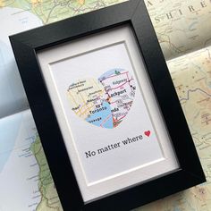 a black frame holds a map with a heart and the words, no matter where