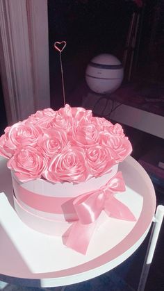 a cake with pink roses and a heart on top