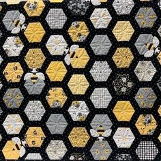 a black and yellow quilt with hexagons on it's sides,