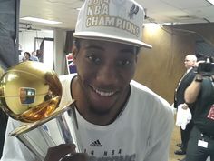 a young man holding up a trophy in front of his face and taking a selfie