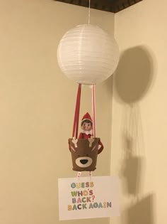 a paper ball hanging from the ceiling next to a sign