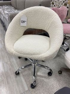 a white chair with wheels and a price tag on the back is sitting in a store