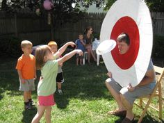 a man holding a white frisbee in front of two children and an adult