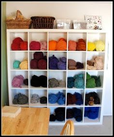 there are many balls of yarn on the shelves in this room, all different colors