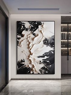 an abstract painting hangs in the middle of a room with white and black decor on the walls