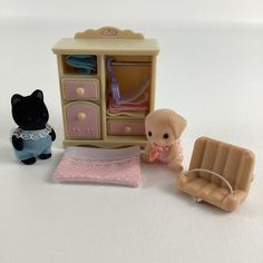 a small doll house set with furniture and baby items on the floor, including a toy car