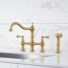 two golden faucets on a marble counter top