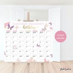 a baby's birthday calendar on a easel in a room with wooden floors