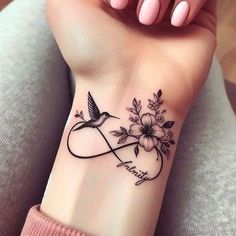 a woman's wrist tattoo with flowers and a bird on it that says, i love