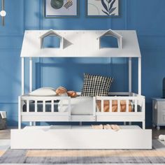 a child's bed with a white frame and mattress underneath it in a blue room