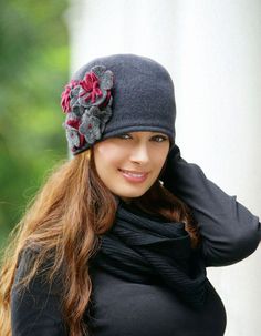 a woman wearing a gray hat with flowers on it