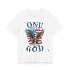 Wear your faith and patriotism boldly with our "One Nation Under God" patriotic T-shirt. It features a striking design of an American Bald Eagle, a Cross, and the iconic American flag. Crafted from Bella Canvas 3001 T-shirt blanks, this premium garment offers unmatched comfort and style. The symbolic design embodies the unity of faith and national pride, with the Bald Eagle symbolizing strength and freedom standing behind the Cross, a testament to our nation's foundation on Christian principles. Veterans Day Graphic Tee With Short Sleeves, Patriotic American Flag T-shirt For Independence Day, Americana T-shirt With American Flag For 4th Of July, American Flag T-shirt For Independence Day, Patriotic 4th Of July Graphic T-shirt, Patriotic Flag Print T-shirt For 4th Of July, Patriotic T-shirt With Flag Print For 4th Of July, American Style T-shirt With American Flag For Independence Day, 4th Of July American Flag T-shirt