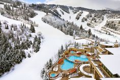 an aerial view of a ski resort and pool surrounded by trees in the wintertime