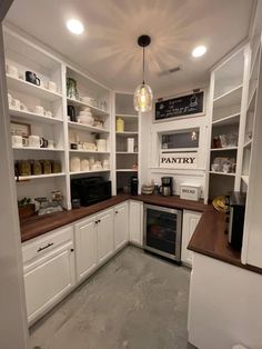 a kitchen with white cabinets and wood counter tops, an oven in the center is surrounded by open shelving