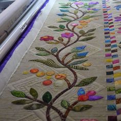 a close up of a quilting machine with colorful flowers on it's side