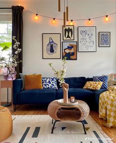 a living room with blue couches and pictures on the wall above it's coffee table