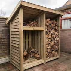 a wooden shed with logs stacked in it