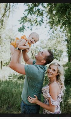 a man holding a baby up in the air