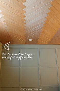 the ceiling is covered with wood planks and has a quote written in white on it