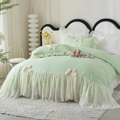 a bed with green comforter and white sheets