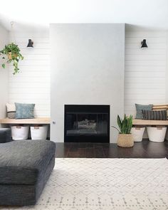 a living room filled with furniture and a fire place next to a wall mounted tv