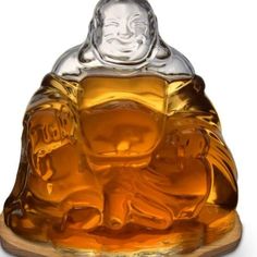 a glass buddha figurine sitting on top of a wooden base