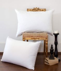 two white pillows sitting next to each other on top of a wooden floor