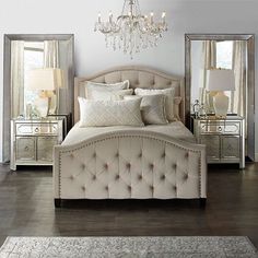 a large bed sitting in a bedroom under a chandelier