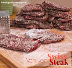 several steak patties are on a cutting board with a knife and fork next to them