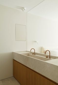 two sinks in a bathroom with white walls