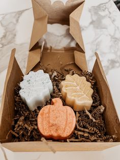 three soaps in a cardboard box on a table