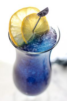 a blue drink garnished with lemon wedges and a toothpick sticking out of the top